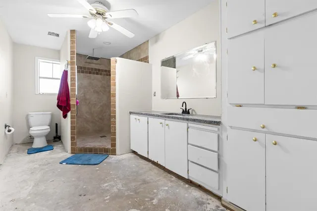 a bathroom with a sink a toilet and shower