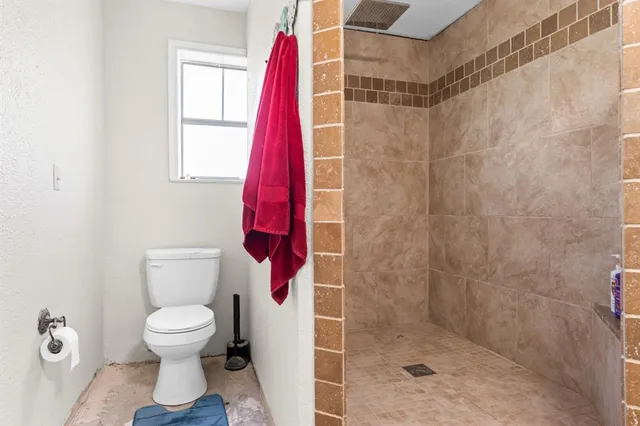 a bathroom with a toilet and a shower