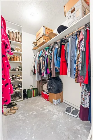 a view of walk in closet with clothes and shoes