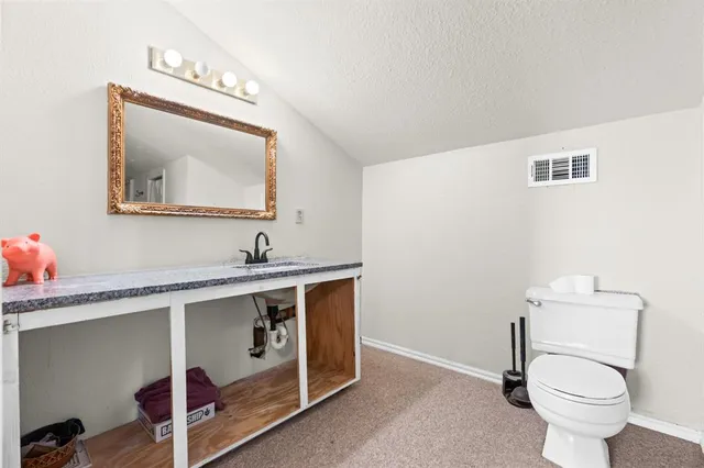 a spacious bathroom with a toilet sink and mirror
