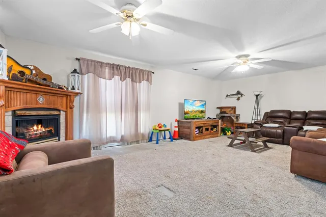 a living room with furniture a fireplace and a chandelier