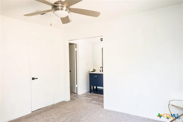 a view of a room with a ceiling fan and a bathroom