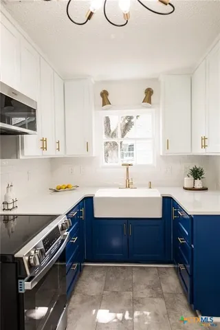 a kitchen with a sink a stove and cabinets