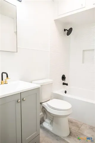 a white toilet sitting next to a bathroom sink