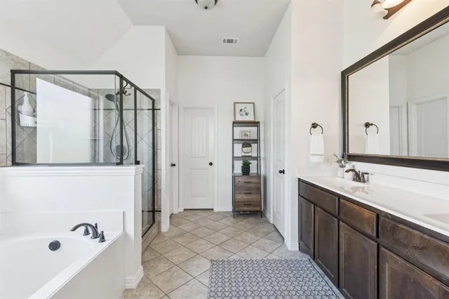 a bathroom with a tub sink and mirror