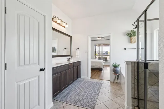 a spacious bathroom with a double vanity sink a large mirror a bathtub and a shower