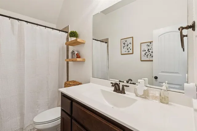 a bathroom with a sink vanity mirror and toilet