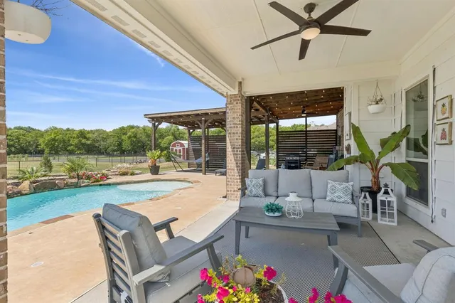 a living room with patio furniture and a floor to ceiling window