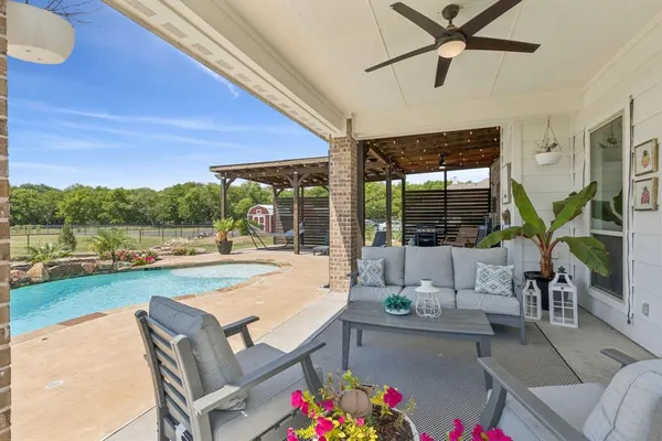 a living room with patio furniture and a floor to ceiling window