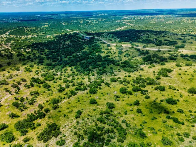 a view of a green field with lots of bushes