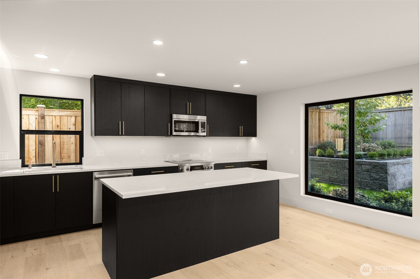 6833 36th Avenue Northeast Seattle, WA 98115 - Photo 24 of 40 a kitchen with stainless steel appliances a sink a stove a refrigerator cabinets and a window