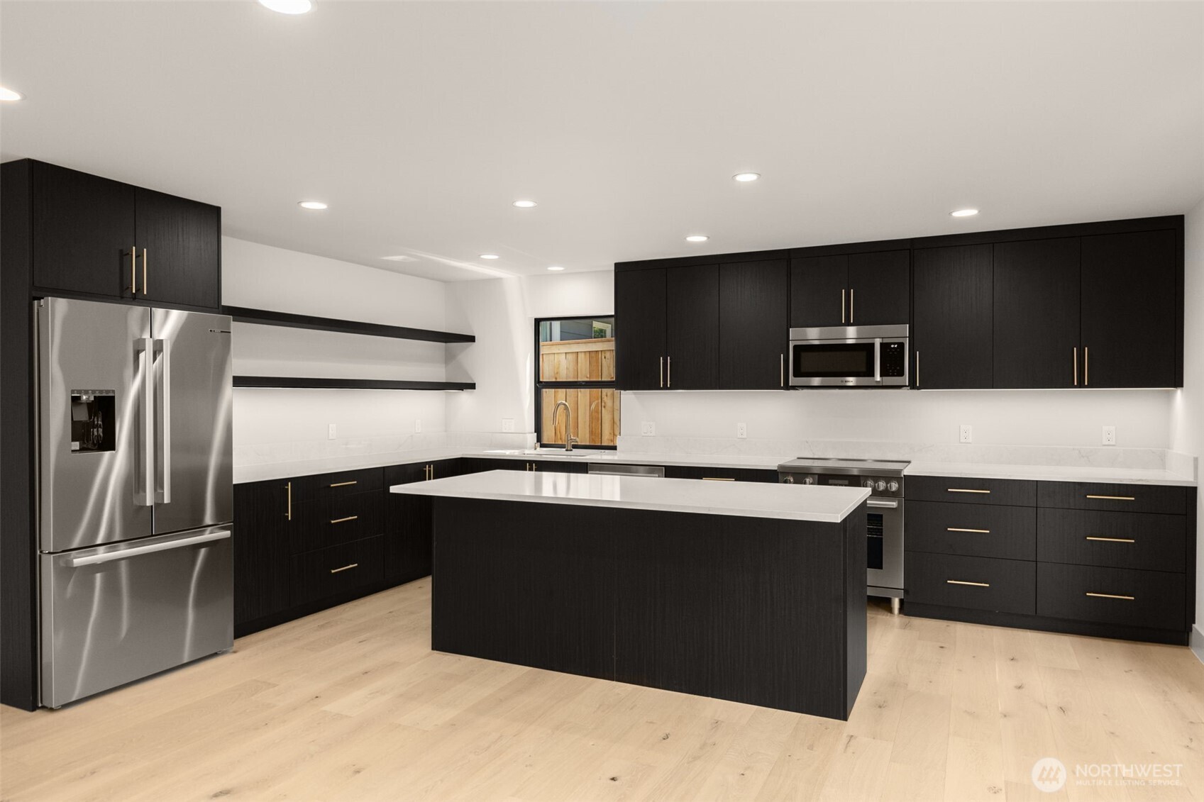 6833 36th Avenue Northeast Seattle, WA 98115 - Photo 29 of 40 a kitchen with stainless steel appliances kitchen island granite countertop a refrigerator and a sink