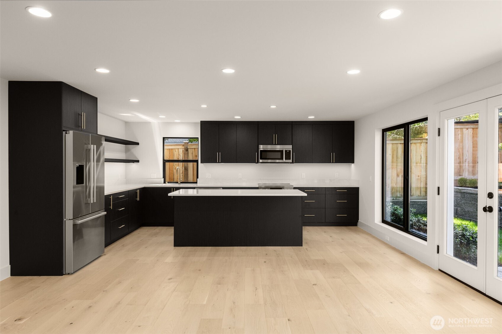 6833 36th Avenue Northeast Seattle, WA 98115 - Photo 30 of 40 a large kitchen with stainless steel appliances kitchen island granite countertop a refrigerator oven a sink with a countertops and wooden floor