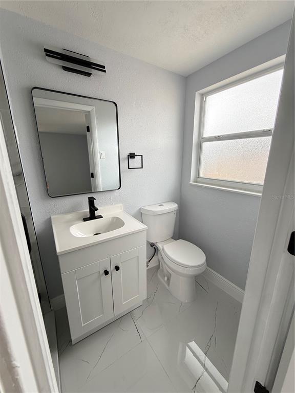 10433 Laburnum Drive Port Richey, FL 34668 - Photo 14 of 26 a bathroom with a toilet sink and mirror