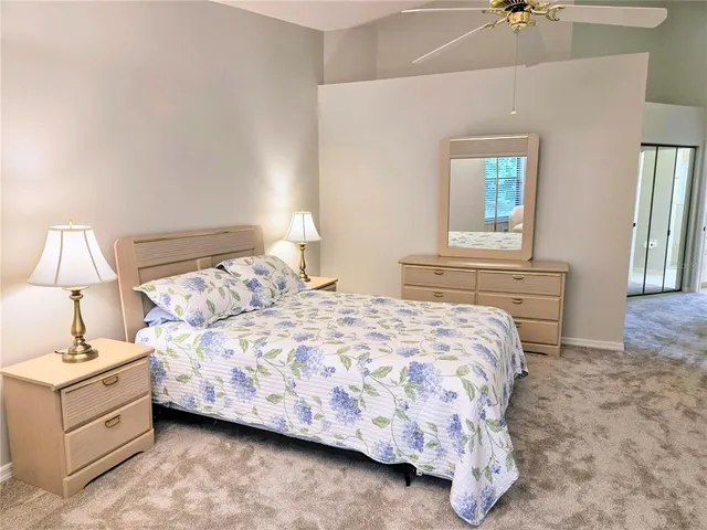 a bedroom with a bed and a chandelier fan
