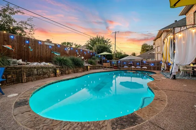 a view of a house with backyard sitting area and swimming pool