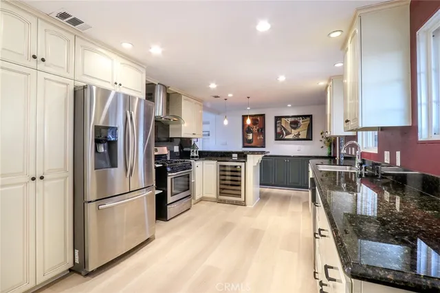 a kitchen with stainless steel appliances granite countertop a refrigerator stove microwave and sink