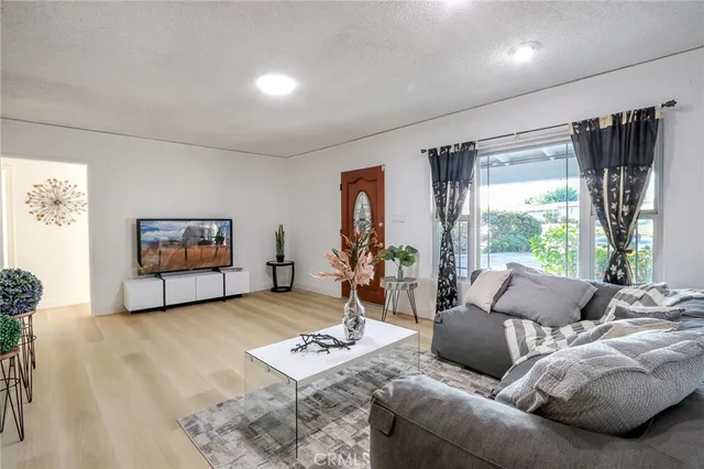 a living room with furniture a window and a flat screen tv
