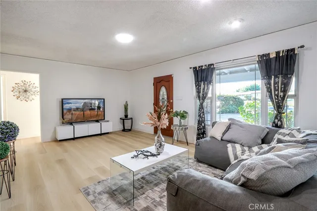 a living room with furniture a window and a flat screen tv
