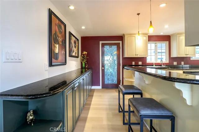 a kitchen with a sink a counter and chairs