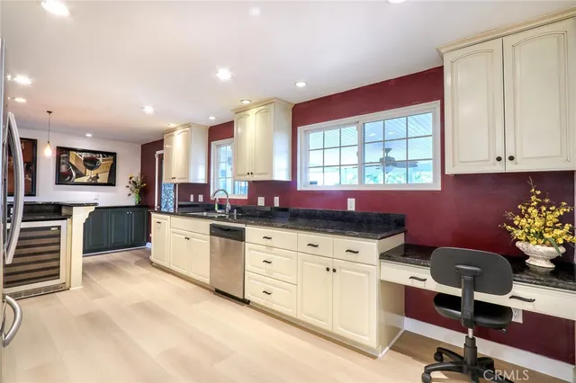 a kitchen with granite countertop a stove a sink cabinets and wooden floor