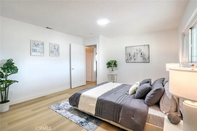 a bedroom with a bed and painting on the wall