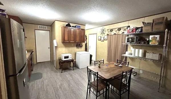 a kitchen with refrigerator and chairs