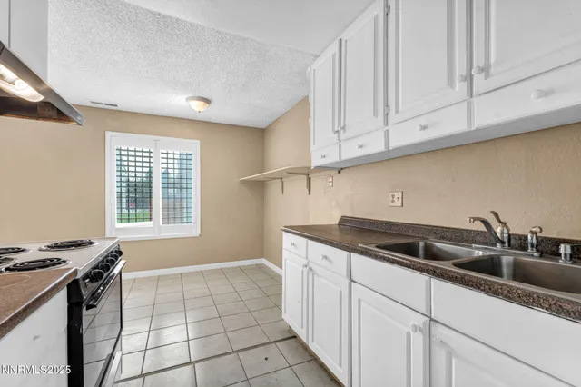 a kitchen with a stove top oven and cabinets