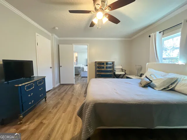 a bedroom with a large bed and a chandelier