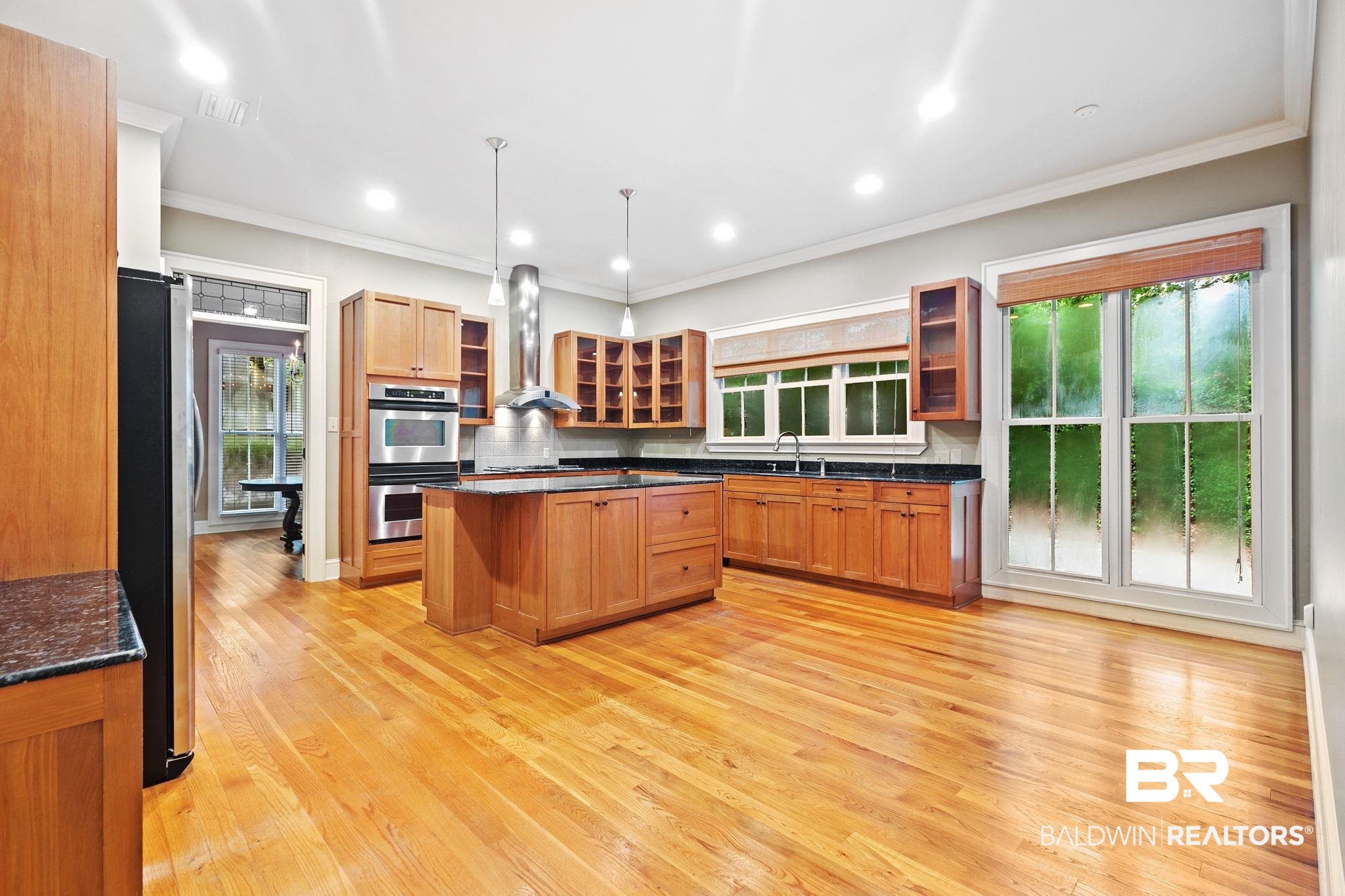 202 Beall Lane Daphne, AL 36526 - Photo 14 of 46 Kitchen with light hardwood / wood-style flooring, wall chimney range hood, a center island, appliances with stainless steel finishes, and decorative light fixtures