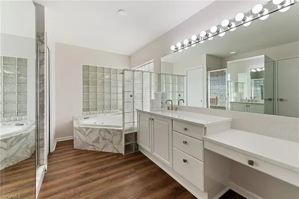 a spacious bathroom with a double vanity sink a large mirror and a bathtub