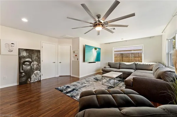 a living room with furniture and a wooden floor