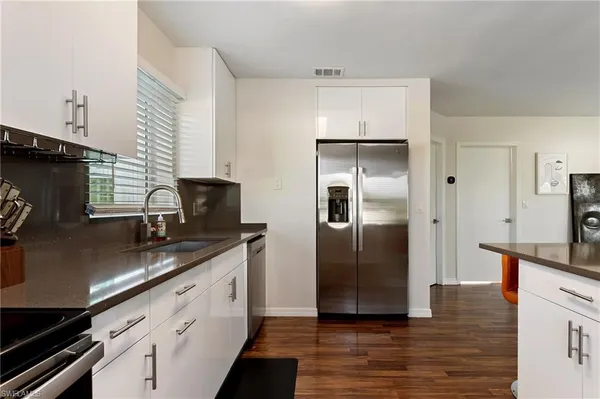 a kitchen with granite countertop a refrigerator and a sink