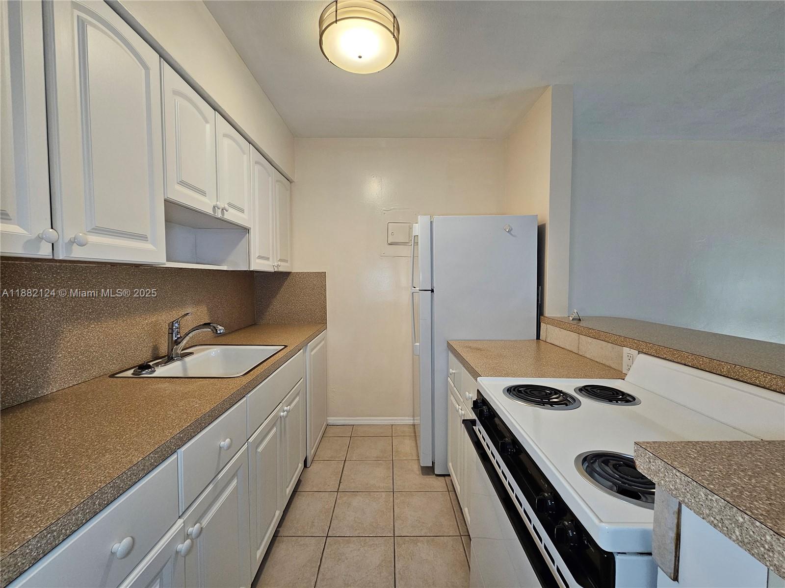 3217 Northeast 7th Place, Unit 2 Pompano Beach, FL 33062 - Photo 11 of 20 a kitchen that has a sink and a stove