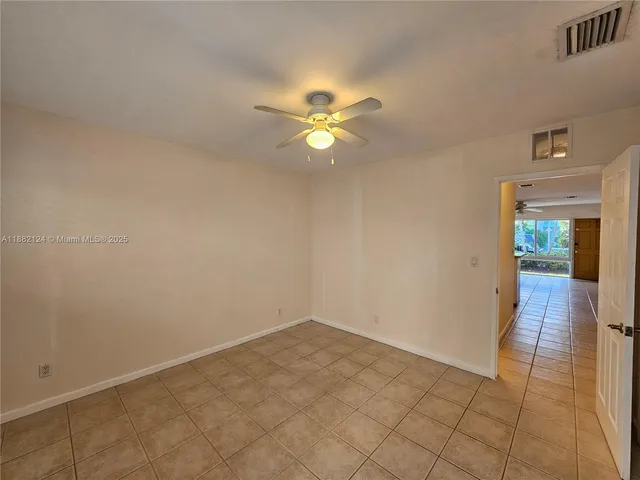 an empty room with closet and a ceiling fan