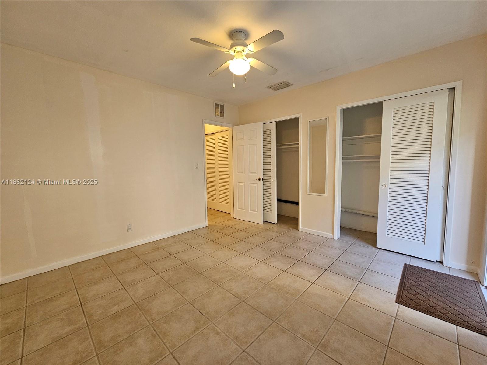 3217 Northeast 7th Place, Unit 2 Pompano Beach, FL 33062 - Photo 16 of 20 an empty room with closet and a ceiling fan