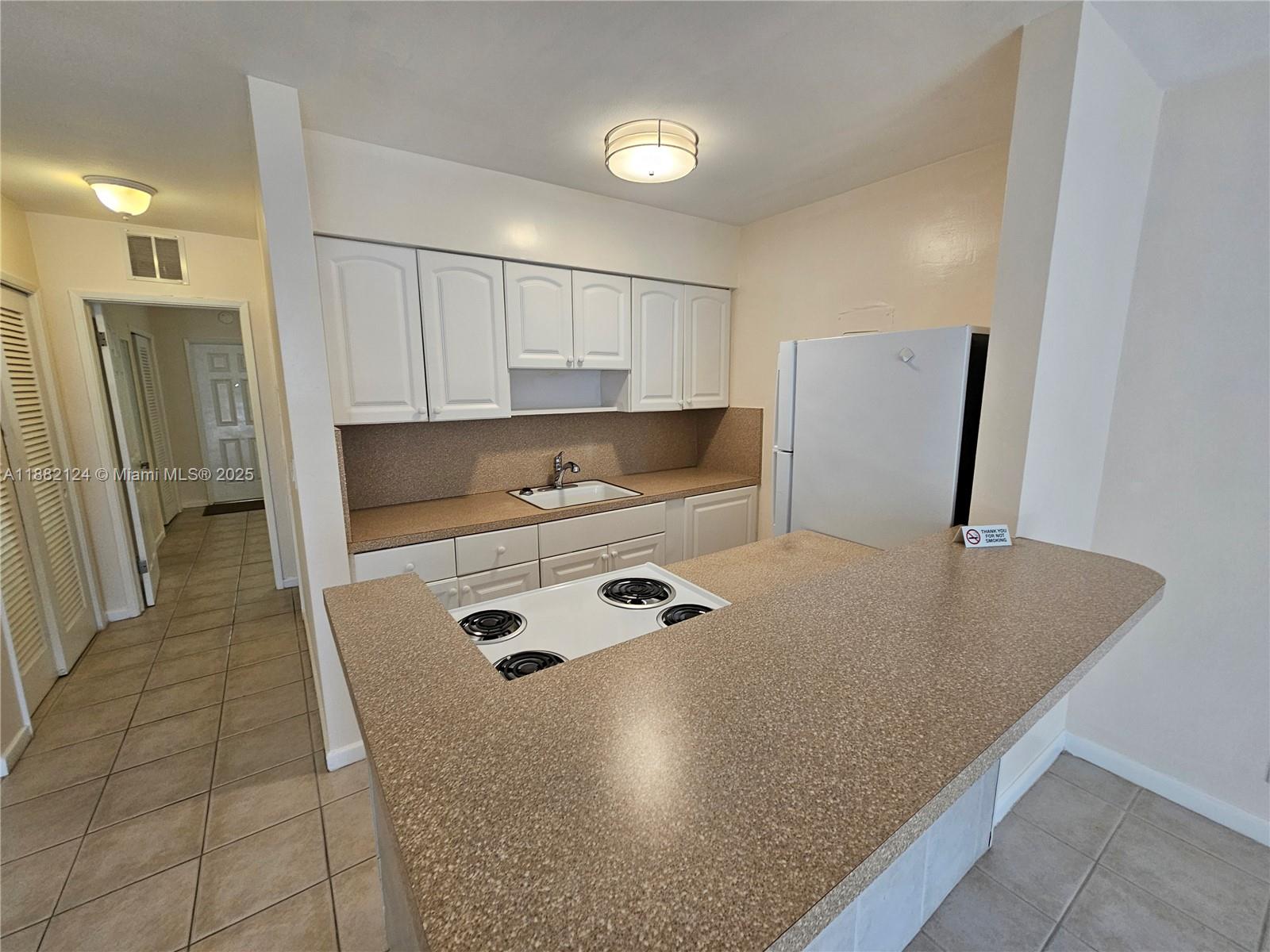 3217 Northeast 7th Place, Unit 2 Pompano Beach, FL 33062 - Photo 8 of 20 a kitchen with stainless steel appliances granite countertop a sink refrigerator and cabinets