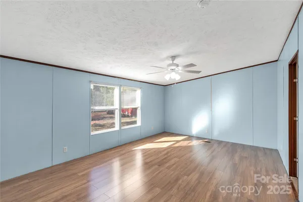 a view of an empty room with closet and a window