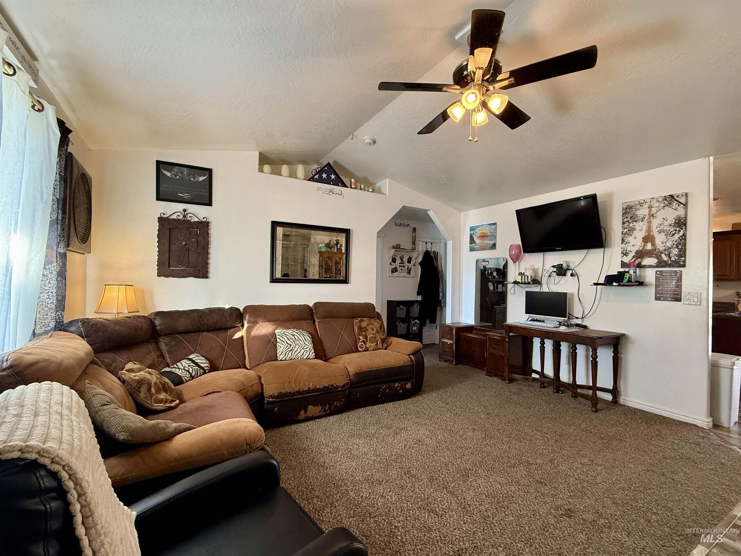 1141 Sunset Lane Kimberly, ID 83341 - Photo 4 of 6 Living room with carpet, a ceiling fan, a textured ceiling, and arched walkways
