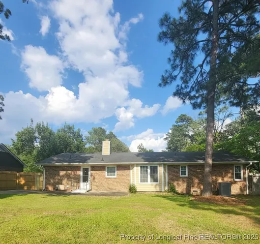a view of a house with a big yard and large trees