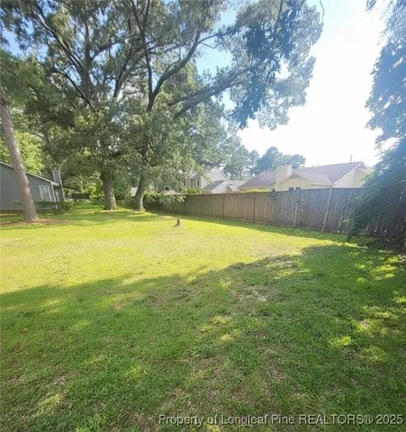 a view of a large pool with lawn chairs under an umbrella