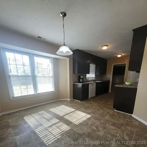 a kitchen with stainless steel appliances kitchen island granite countertop a sink a stove top oven a counter space and cabinets