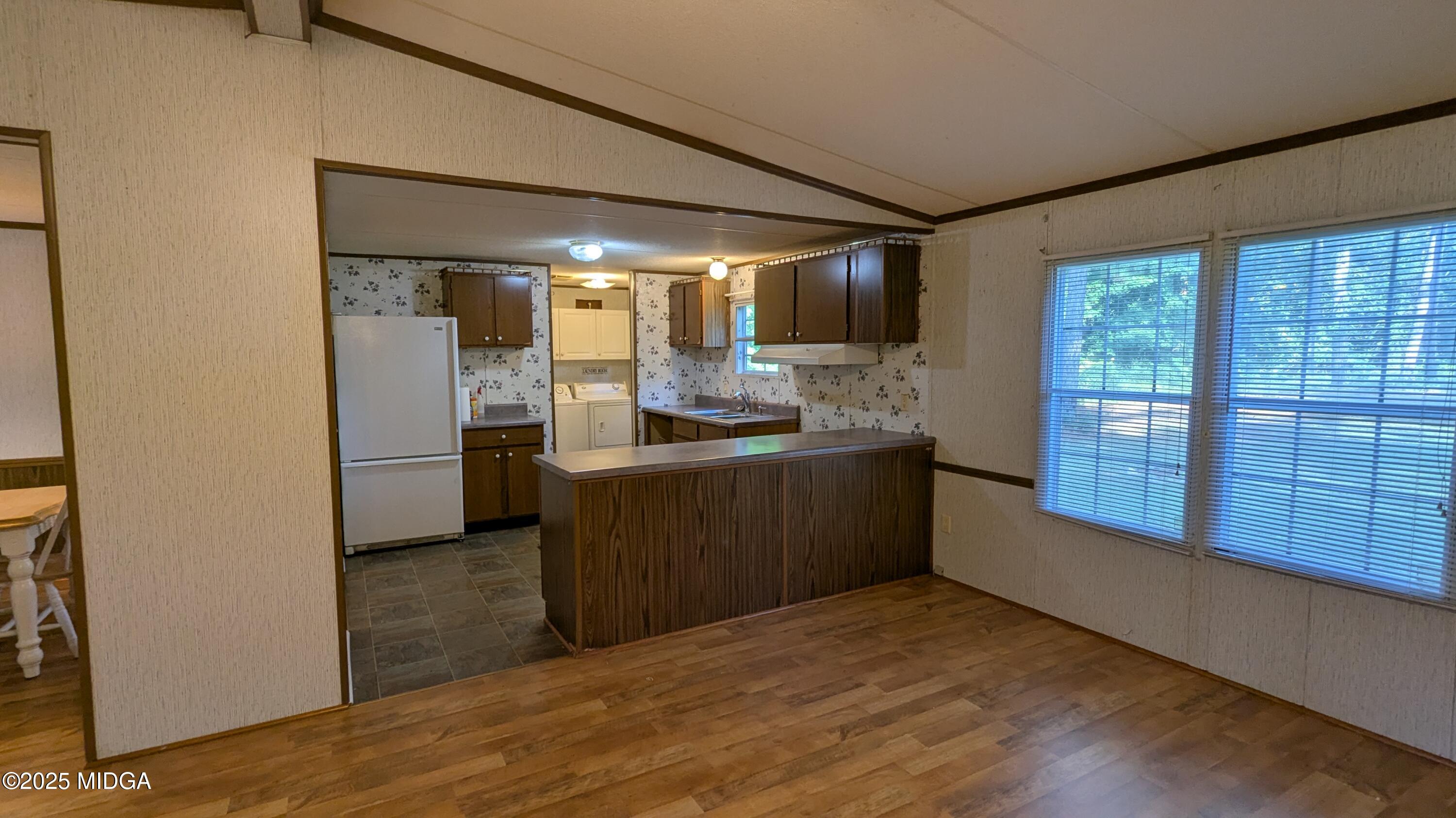 151 Hardy Road Gray, GA 31032 - Photo 8 of 18 a kitchen with granite countertop a refrigerator and wooden cabinets