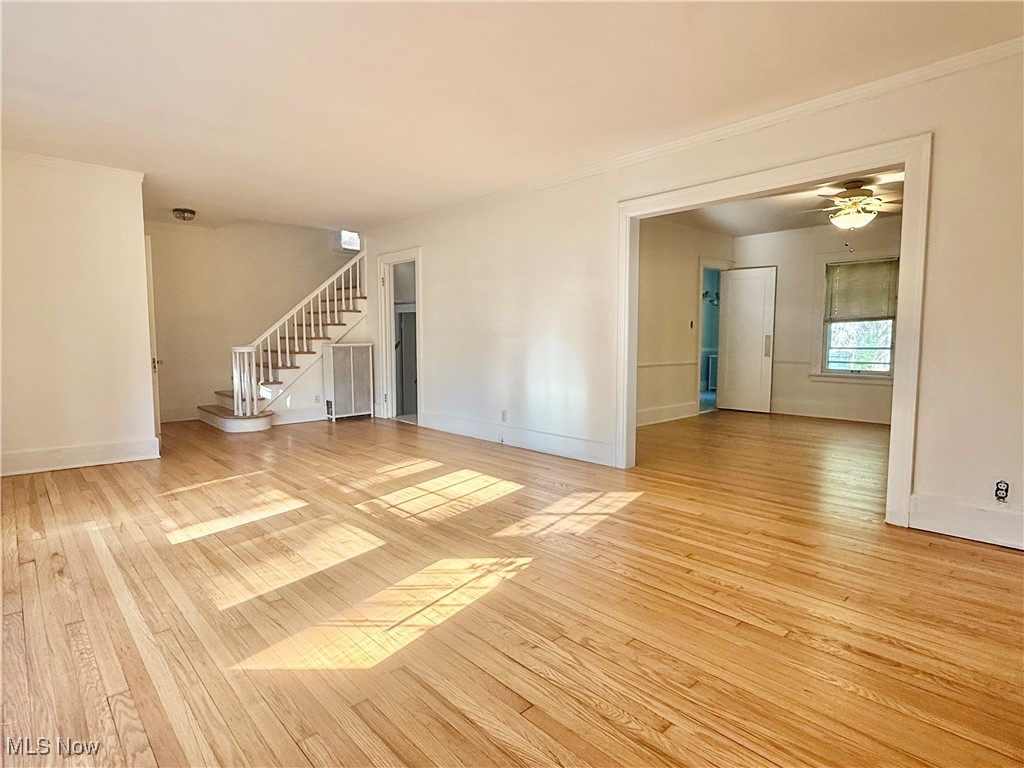 1979 Staunton Road Cleveland, OH 44118 - Photo 11 of 37 Unfurnished living room with stairway, light wood-style flooring, crown molding, and ceiling fan