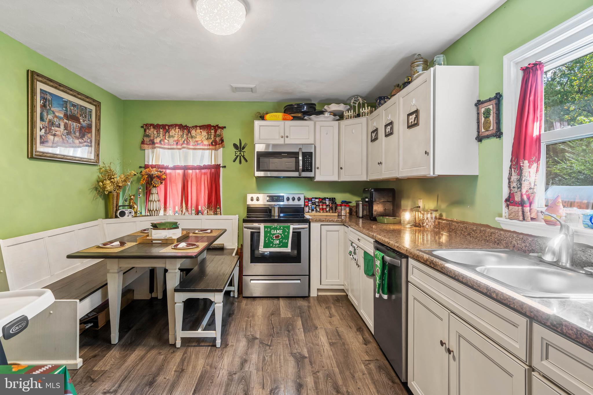 32197 Johnson Road Salisbury, MD 21804 - Photo 8 of 23 a kitchen with stainless steel appliances kitchen island granite countertop a sink cabinets and wooden floor