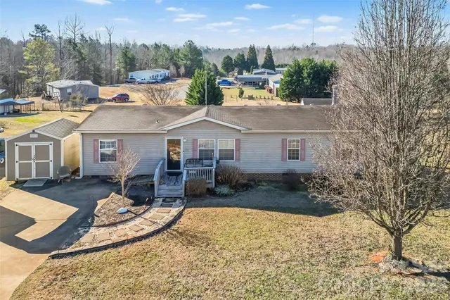 a view of a white house with a yard patio and fire pit