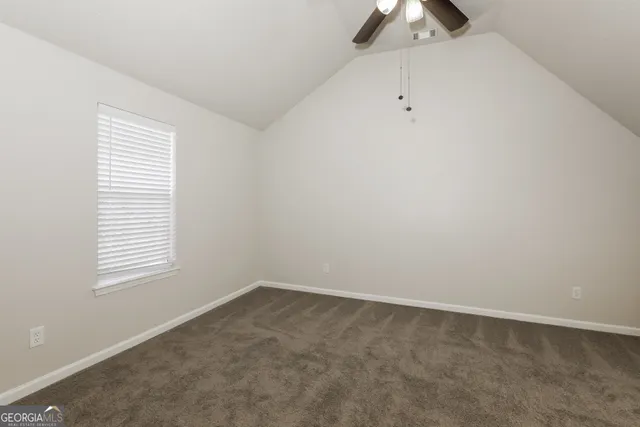 an empty room with a window and a chandelier fan