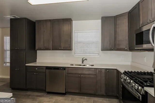 a kitchen with stainless steel appliances granite countertop a sink stove and refrigerator