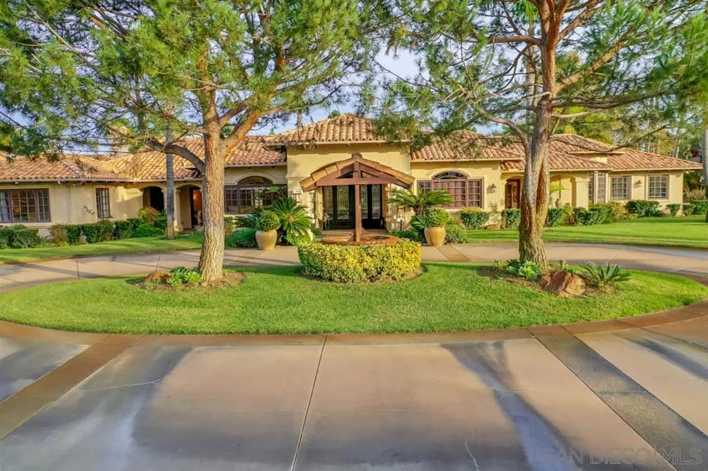 15611 Via De Santa Fe Rancho Santa Fe, CA 92067 - Photo 1 of 25 a front view of a house with a yard and trees