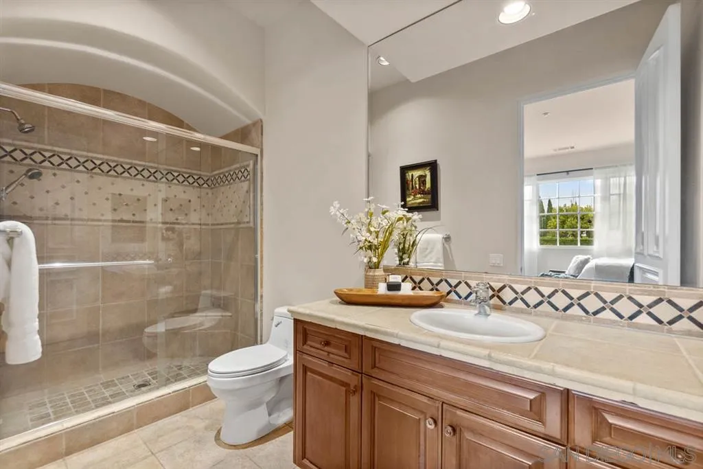 15611 Via De Santa Fe Rancho Santa Fe, CA 92067 - Photo 14 of 25 a bathroom with a sink toilet a mirror and shower